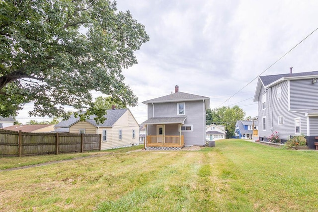 rear view of property with a yard and central AC unit