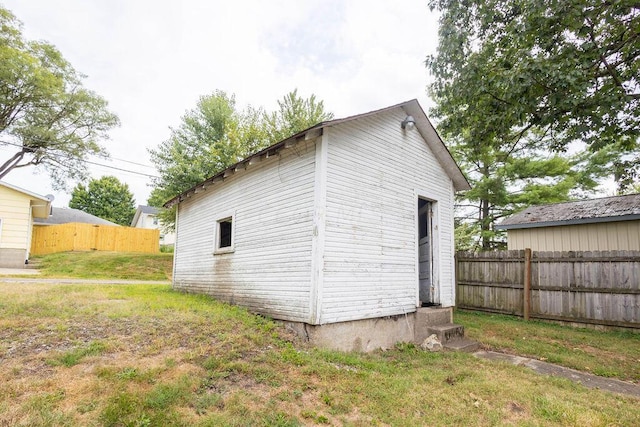 view of side of home with a yard and an outbuilding