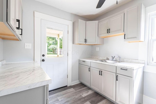 kitchen with ceiling fan, sink, and light hardwood / wood-style flooring