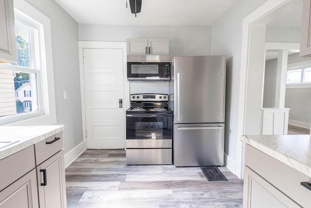 kitchen with plenty of natural light, light hardwood / wood-style flooring, and appliances with stainless steel finishes