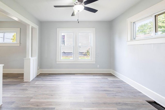 empty room featuring light hardwood / wood-style flooring, a wealth of natural light, and ceiling fan