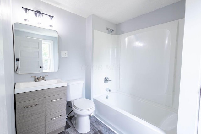 full bathroom with bathing tub / shower combination, toilet, vanity, and hardwood / wood-style flooring