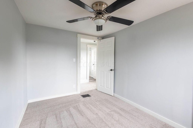 carpeted spare room featuring ceiling fan