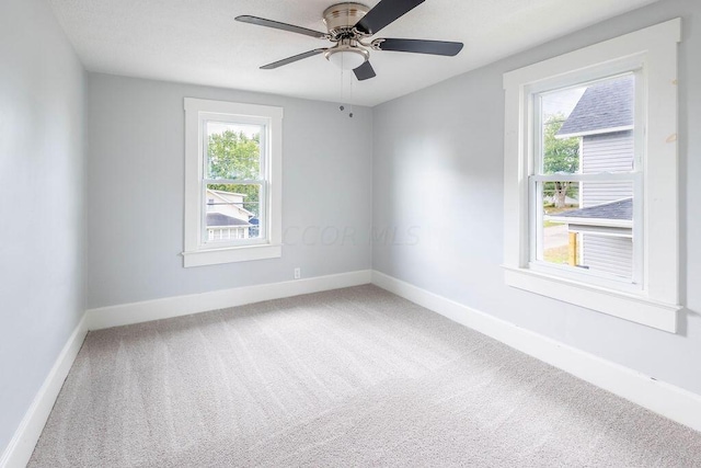 unfurnished room with carpet flooring, ceiling fan, and a healthy amount of sunlight