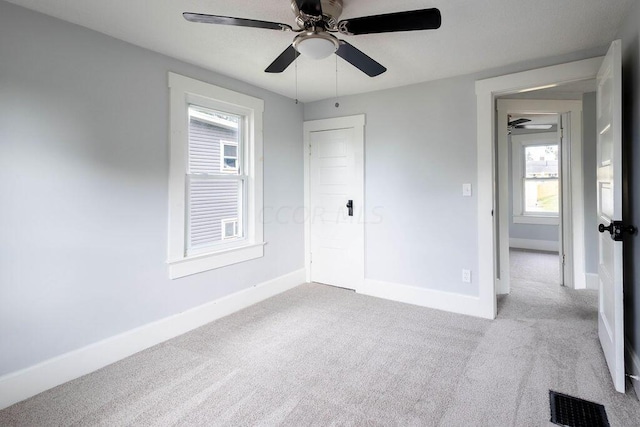 carpeted spare room with ceiling fan