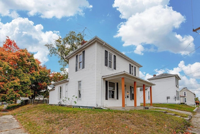 view of front of property with covered porch and a front lawn