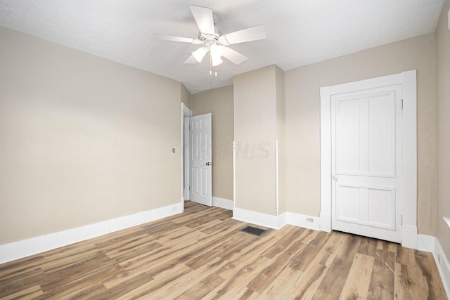 unfurnished bedroom featuring hardwood / wood-style flooring, ceiling fan, and a textured ceiling