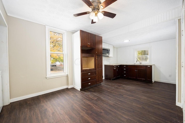 kitchen with ceiling fan, sink, dark wood-type flooring, a textured ceiling, and dark brown cabinets