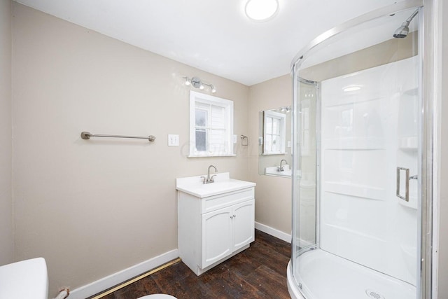 bathroom with wood-type flooring, vanity, toilet, and an enclosed shower