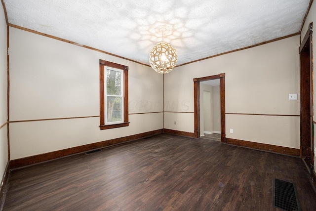 empty room with crown molding, dark wood-type flooring, and a textured ceiling