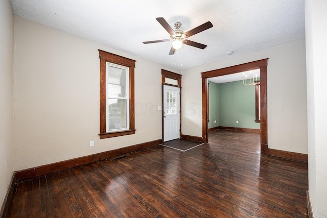 unfurnished room featuring ceiling fan, dark hardwood / wood-style flooring, and a textured ceiling