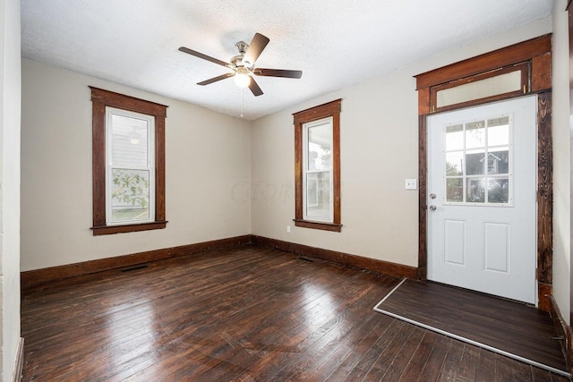 foyer with a textured ceiling, ceiling fan, and dark hardwood / wood-style floors