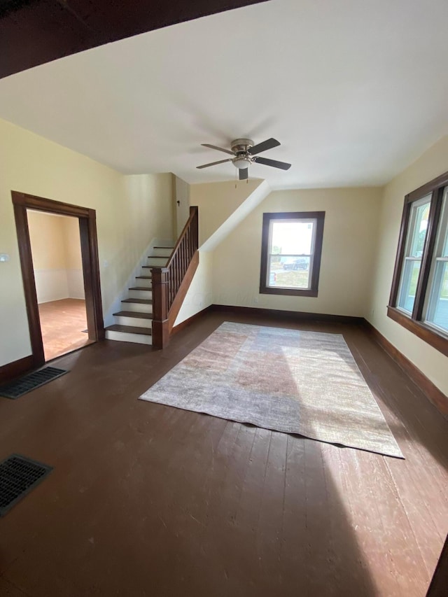 unfurnished living room with ceiling fan and dark hardwood / wood-style flooring