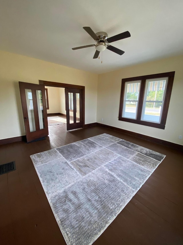 empty room featuring french doors, dark hardwood / wood-style floors, and ceiling fan