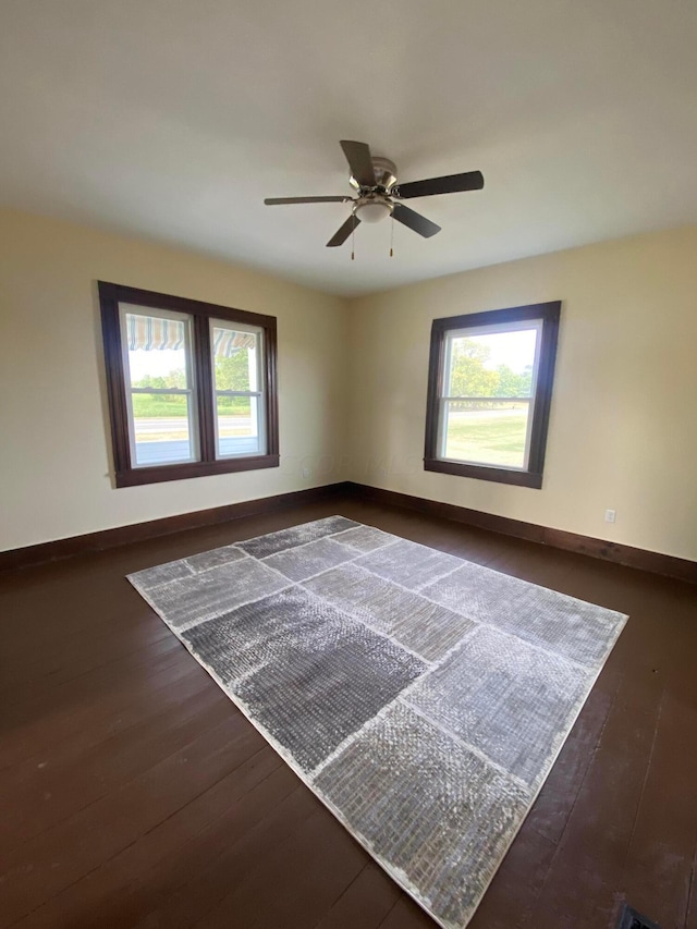 unfurnished room with ceiling fan, a healthy amount of sunlight, and dark hardwood / wood-style flooring