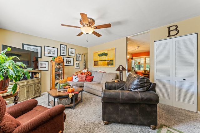 carpeted living room with ceiling fan