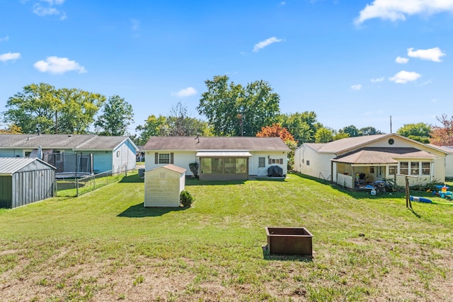 back of property with a yard and a shed