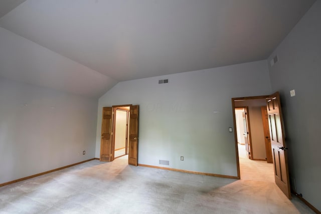 empty room with light carpet and vaulted ceiling