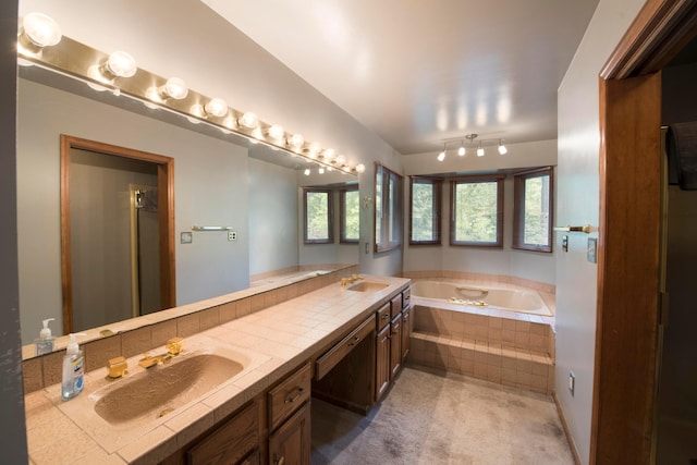 bathroom with vanity and tiled tub