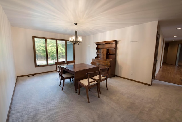 carpeted dining room featuring a notable chandelier