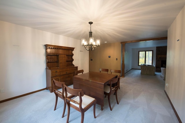 carpeted dining room with a chandelier and a brick fireplace