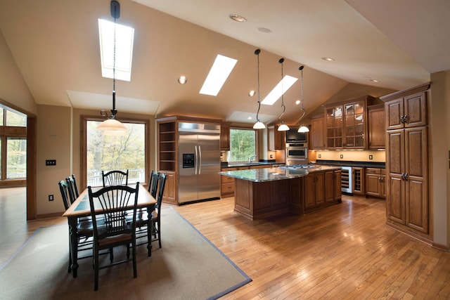 kitchen featuring a skylight, a wealth of natural light, built in fridge, and light hardwood / wood-style floors