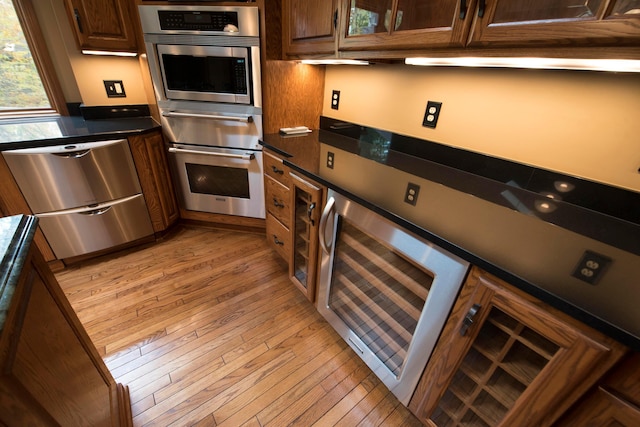 kitchen featuring light hardwood / wood-style flooring, beverage cooler, and stainless steel appliances