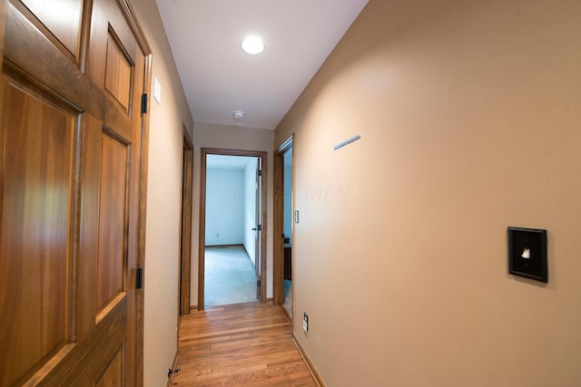 corridor with lofted ceiling and light hardwood / wood-style flooring