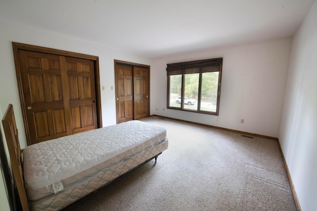 carpeted bedroom with two closets