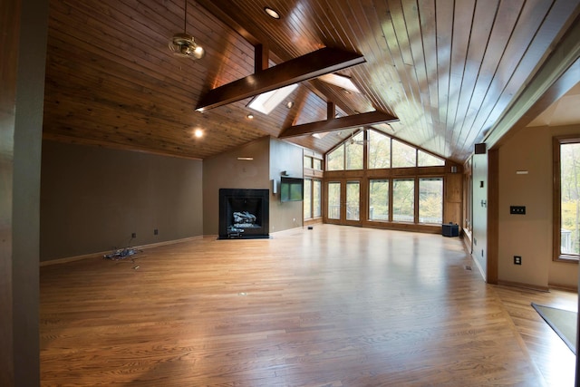 unfurnished living room with a skylight, beam ceiling, high vaulted ceiling, wooden ceiling, and light hardwood / wood-style floors