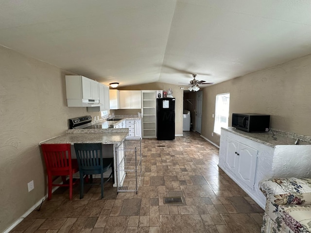 kitchen featuring kitchen peninsula, a kitchen breakfast bar, vaulted ceiling, black appliances, and white cabinets