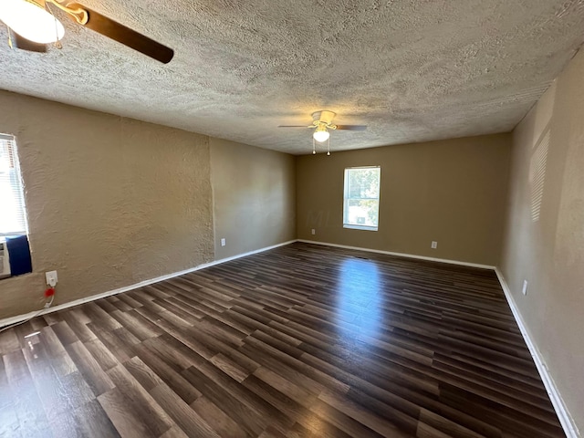 empty room with ceiling fan, dark hardwood / wood-style flooring, and a textured ceiling