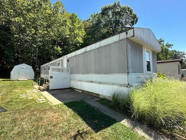 view of side of property featuring a yard and a storage shed