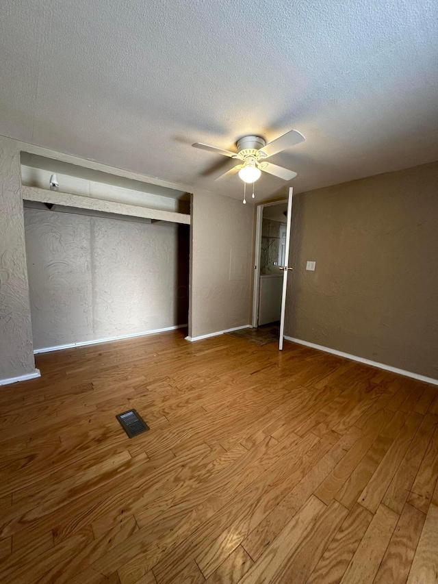 unfurnished bedroom with a closet, ceiling fan, light hardwood / wood-style flooring, and a textured ceiling