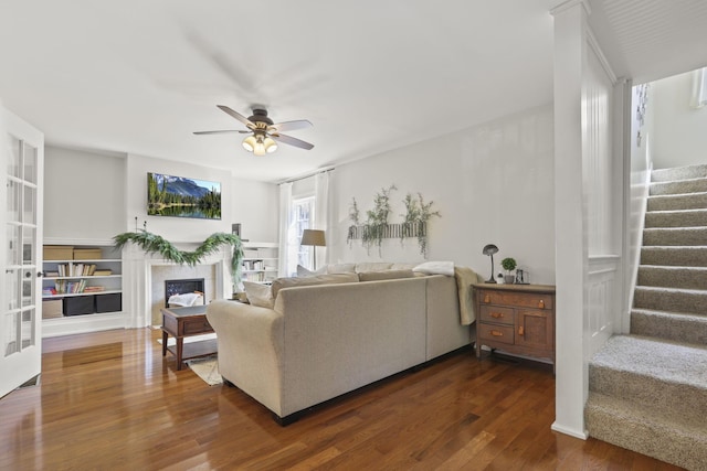 living room featuring ceiling fan and dark hardwood / wood-style flooring