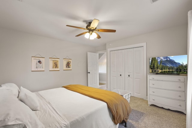 bedroom featuring ceiling fan, a closet, and light colored carpet