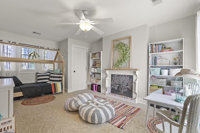 living area featuring carpet and ceiling fan