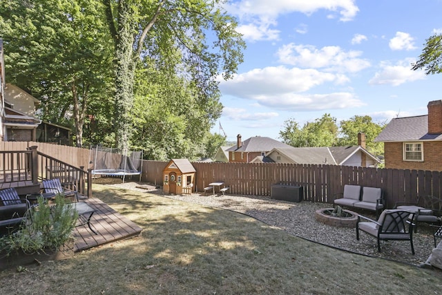 view of yard featuring an outdoor living space, a deck, and a trampoline