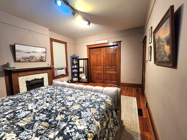 bedroom with hardwood / wood-style floors, cooling unit, and track lighting