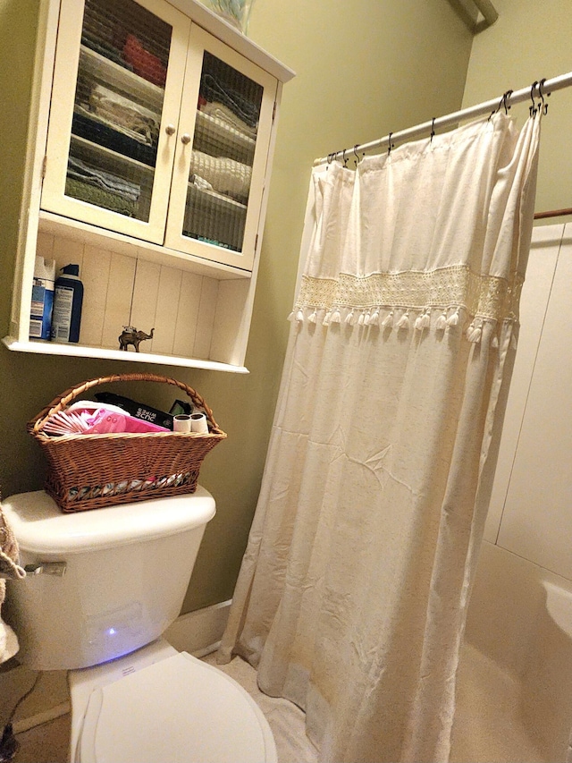 bathroom featuring a shower with curtain and toilet