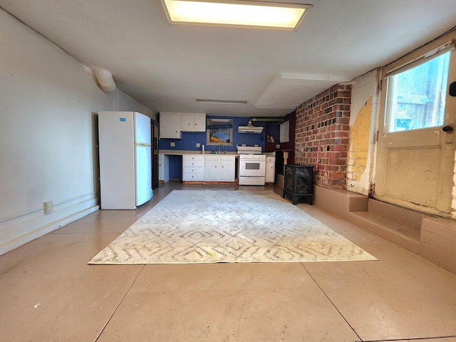 unfurnished living room with a wood stove and sink