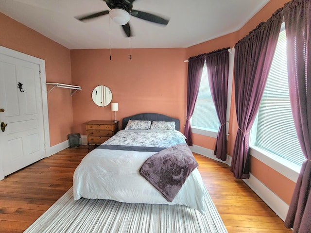 bedroom featuring multiple windows, ceiling fan, and wood-type flooring