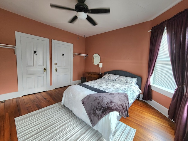 bedroom with multiple windows, ceiling fan, and hardwood / wood-style floors