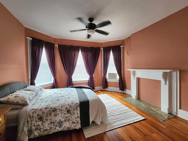 bedroom featuring hardwood / wood-style floors, ceiling fan, and cooling unit