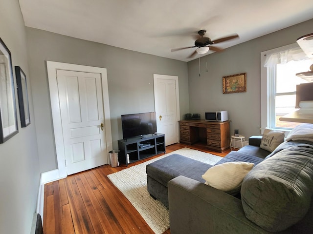 living room with wood-type flooring and ceiling fan