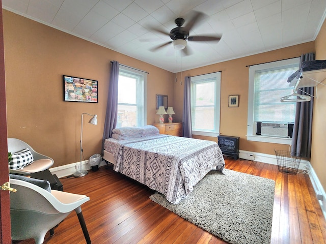 bedroom featuring cooling unit, crown molding, ceiling fan, and dark wood-type flooring