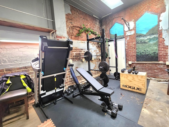 workout area featuring brick wall