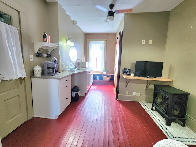 kitchen featuring white cabinetry, sink, ceiling fan, crown molding, and wood-type flooring