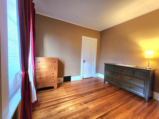 bedroom with wood-type flooring and ornamental molding