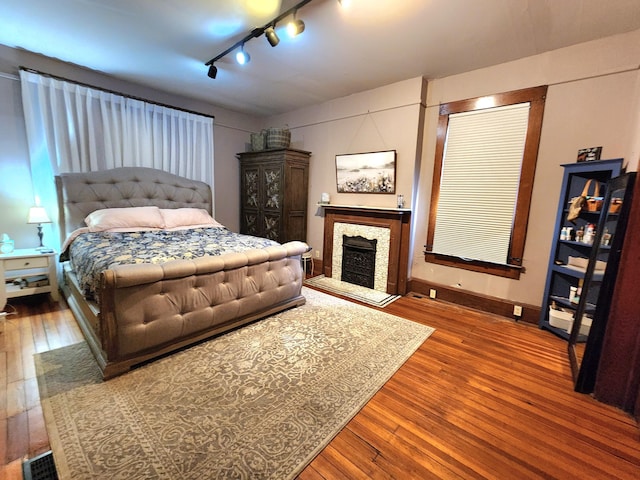 bedroom with hardwood / wood-style floors and rail lighting